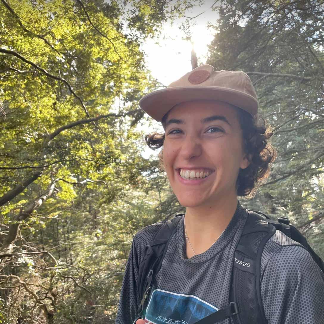 伊莎贝拉 smiles before a background of lush forest